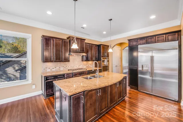 a kitchen with stainless steel appliances granite countertop a sink stove and refrigerator