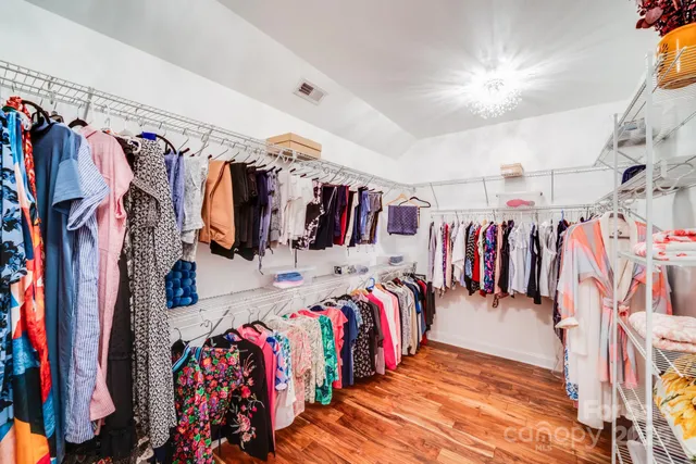 a view of walk in closet with clothes and shoes