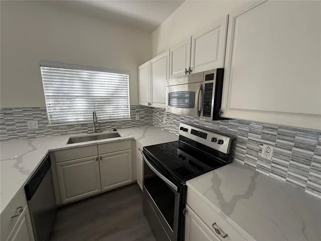 a kitchen with stainless steel appliances a sink stove and microwave