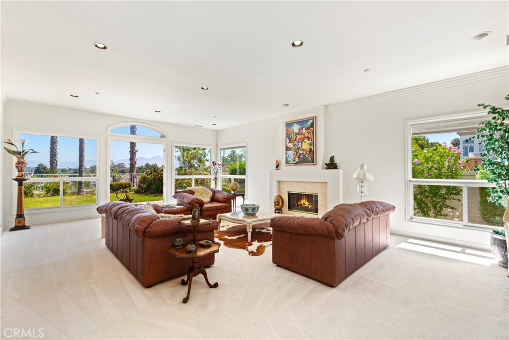 25191 Rockridge Road Laguna Hills, CA 92653 - Photo 4 of 33 a living room with furniture large windows and a fireplace