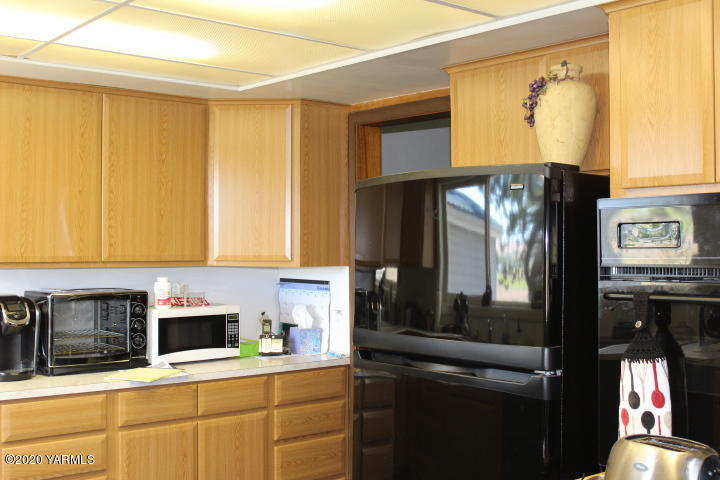 2422 Blaine Road Zillah, WA 98953 - Photo 16 of 39 a kitchen with stainless steel appliances a refrigerator and a stove top oven