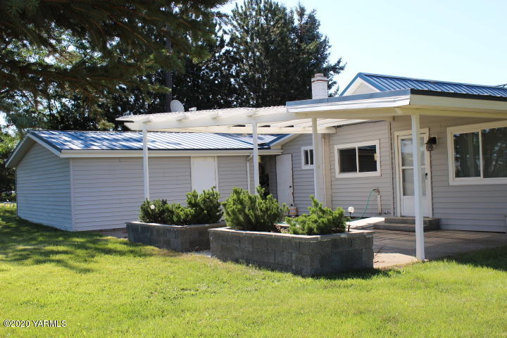2422 Blaine Road Zillah, WA 98953 - Photo 5 of 39 a view of a white house with a yard potted plants and large tree