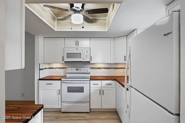 a kitchen with stainless steel appliances a white stove top oven and cabinets