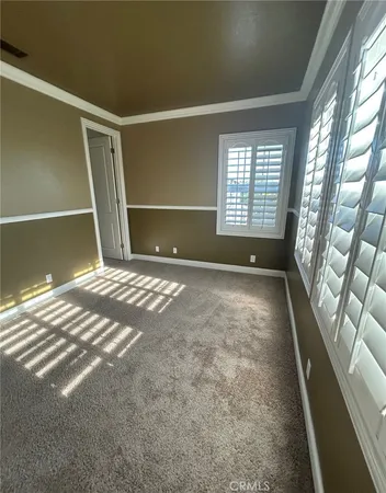 a view of an empty room with a window and fireplace