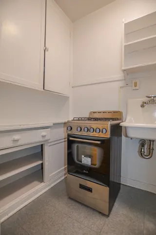 a stove top oven sitting inside of a kitchen