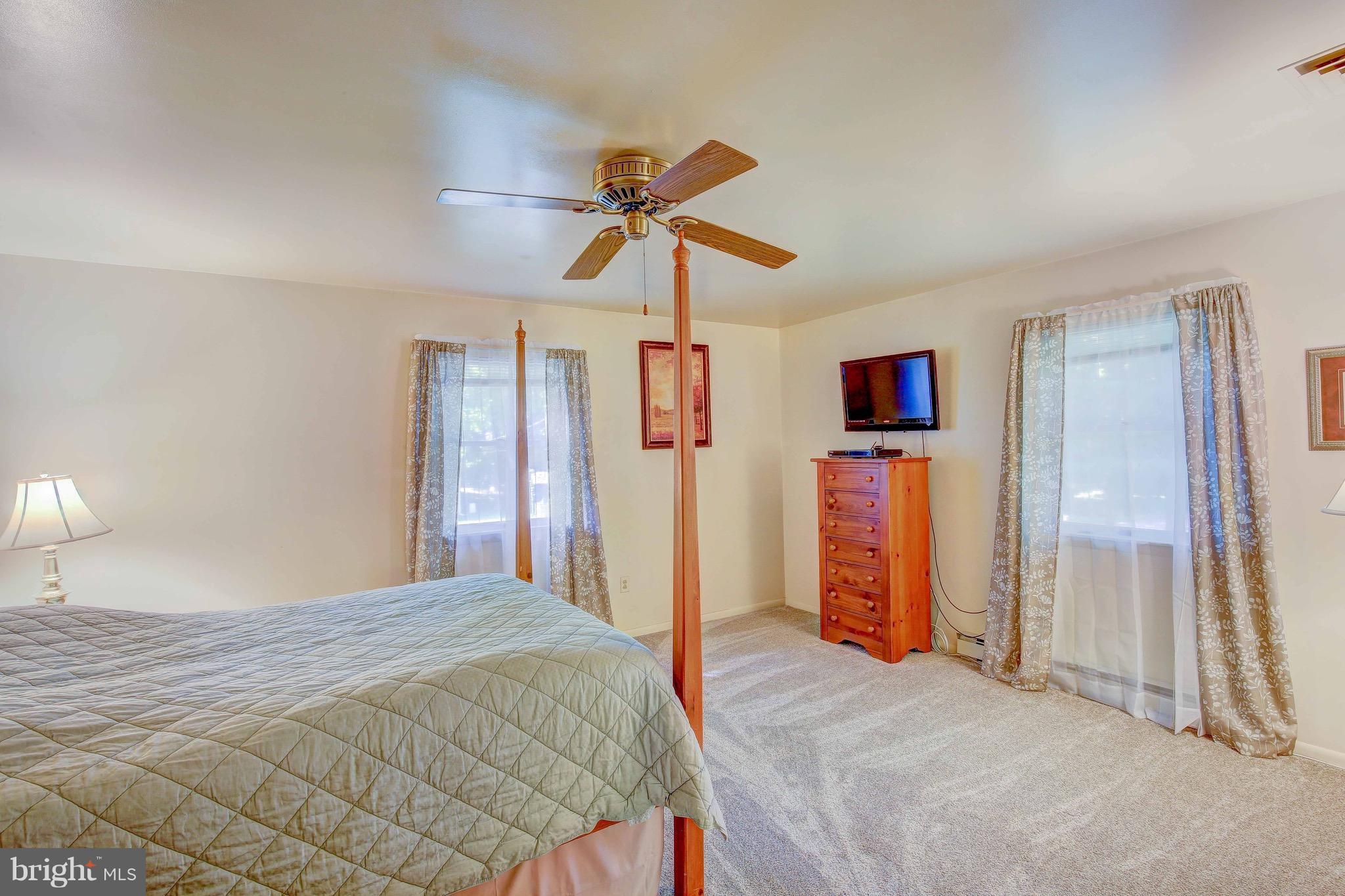 147 Calvert Towne Road Prince Frederick, MD 20678 - Photo 15 of 30 a bedroom with a bed and a chandelier