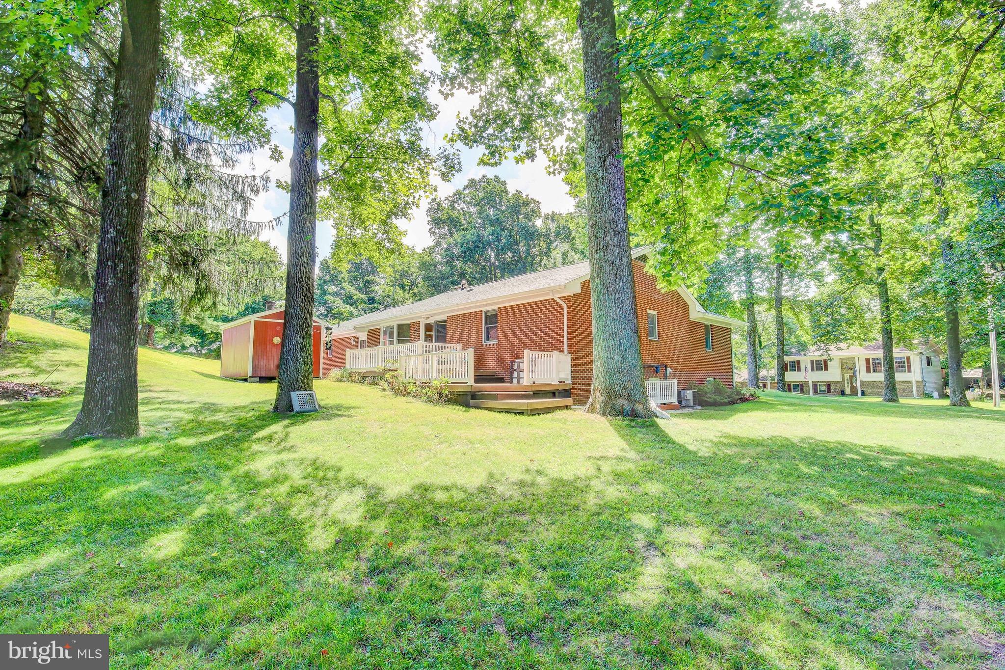 147 Calvert Towne Road Prince Frederick, MD 20678 - Photo 27 of 30 a backyard of a house with table and chairs and large trees