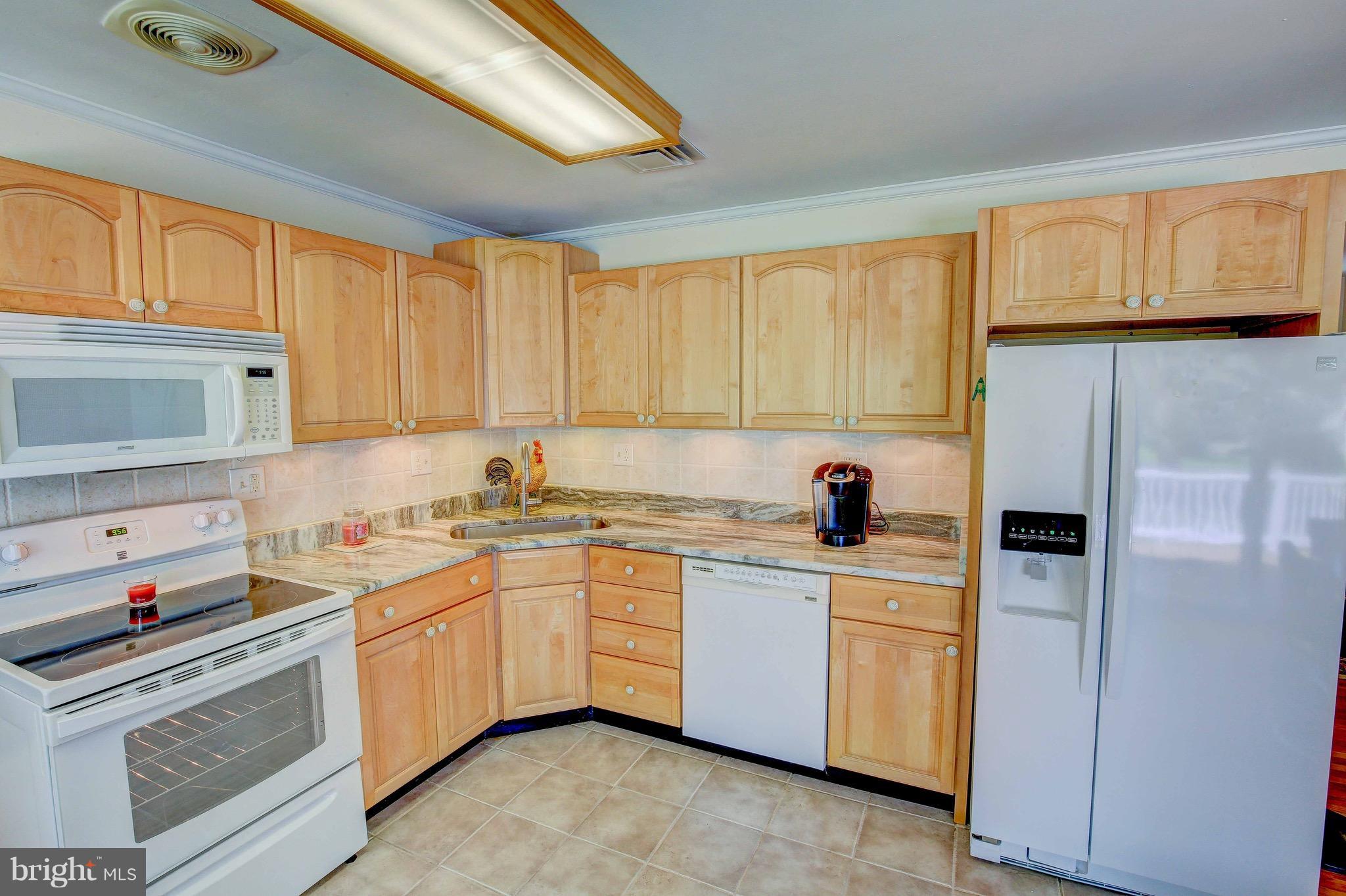 147 Calvert Towne Road Prince Frederick, MD 20678 - Photo 8 of 30 a kitchen with white cabinets sink and white appliances