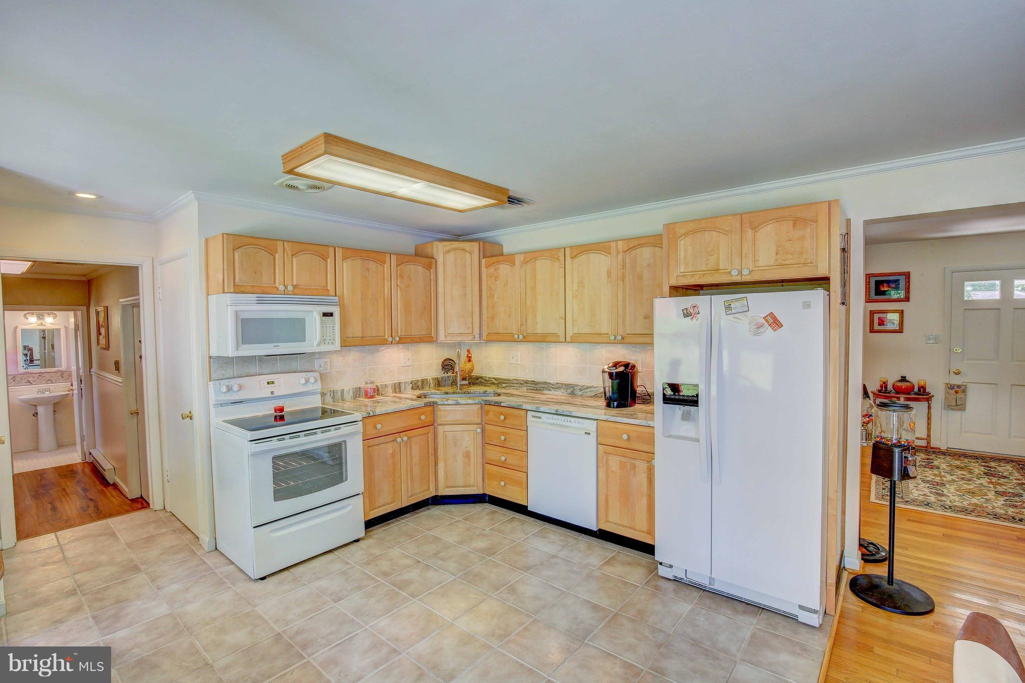 147 Calvert Towne Road Prince Frederick, MD 20678 - Photo 9 of 30 a kitchen with white cabinets and white appliances