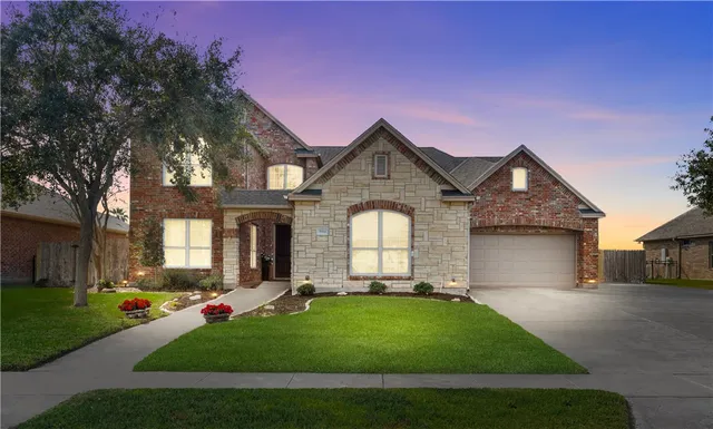 a front view of a house with a yard and garage