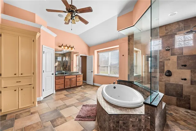 a bathroom with a granite countertop sink a mirror a bathtub and shower
