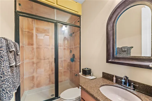 a bathroom with a granite countertop sink toilet and shower