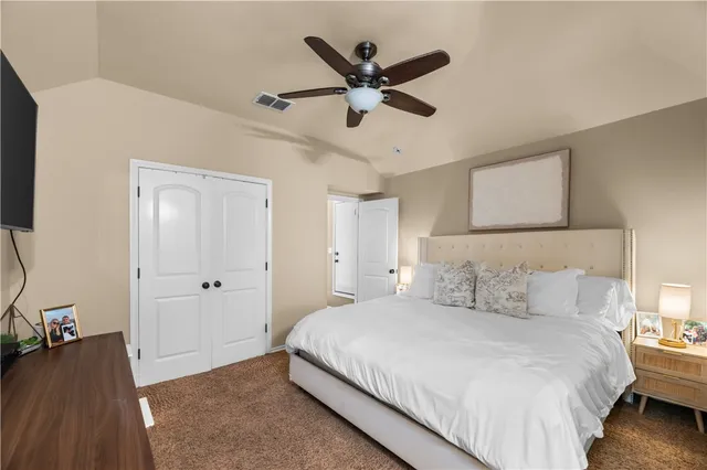 a bedroom with a bed and a ceiling fan