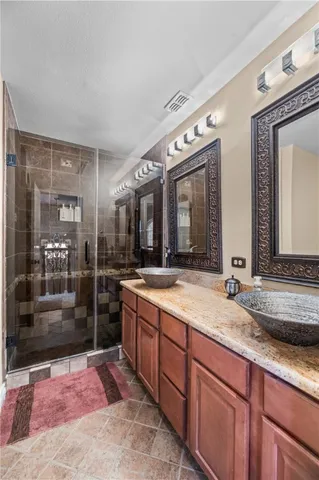a spacious bathroom with a granite countertop sink mirror and shower