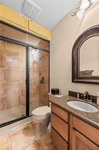 a bathroom with a granite countertop sink toilet and shower