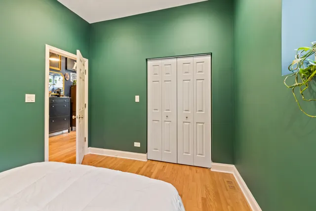 a bedroom with a bed and wooden floor