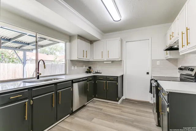 a kitchen with stainless steel appliances granite countertop a sink a stove and a refrigerator