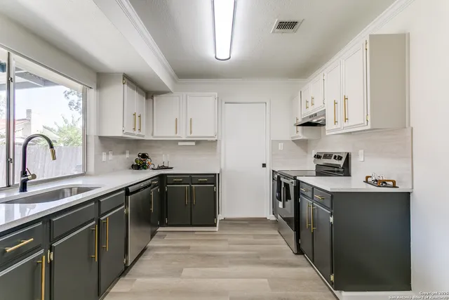 a kitchen with stainless steel appliances granite countertop a stove sink and cabinets