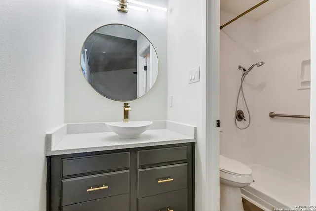 a bathroom with a sink a toilet and a mirror