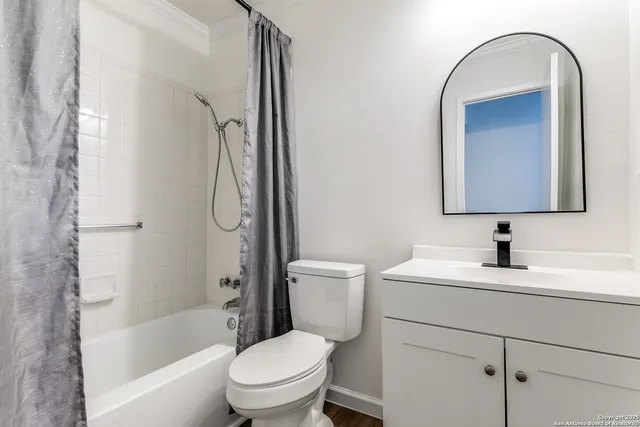 a bathroom with a toilet sink vanity tub and shower