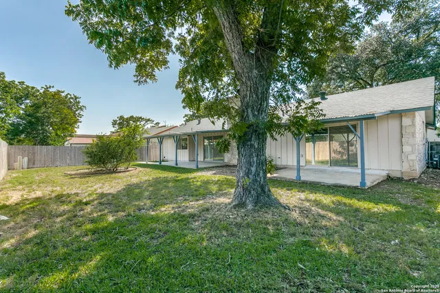 a view of a house with a yard and tree