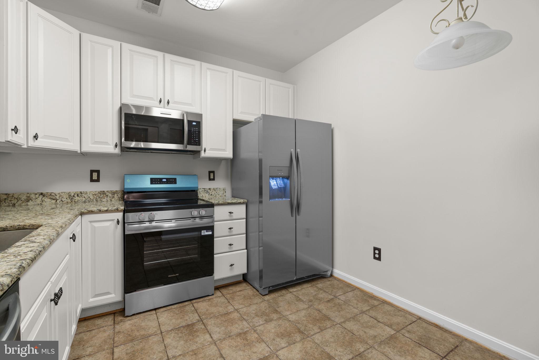 7315 Maplecrest Road, Unit 104 Elkridge, MD 21075 - Photo 17 of 58 a kitchen with stainless steel appliances granite countertop a refrigerator stove and sink