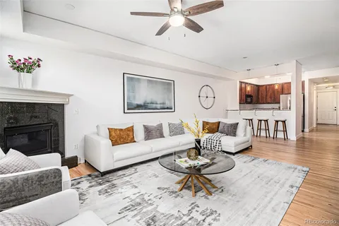 a living room with furniture a fireplace and wooden floor