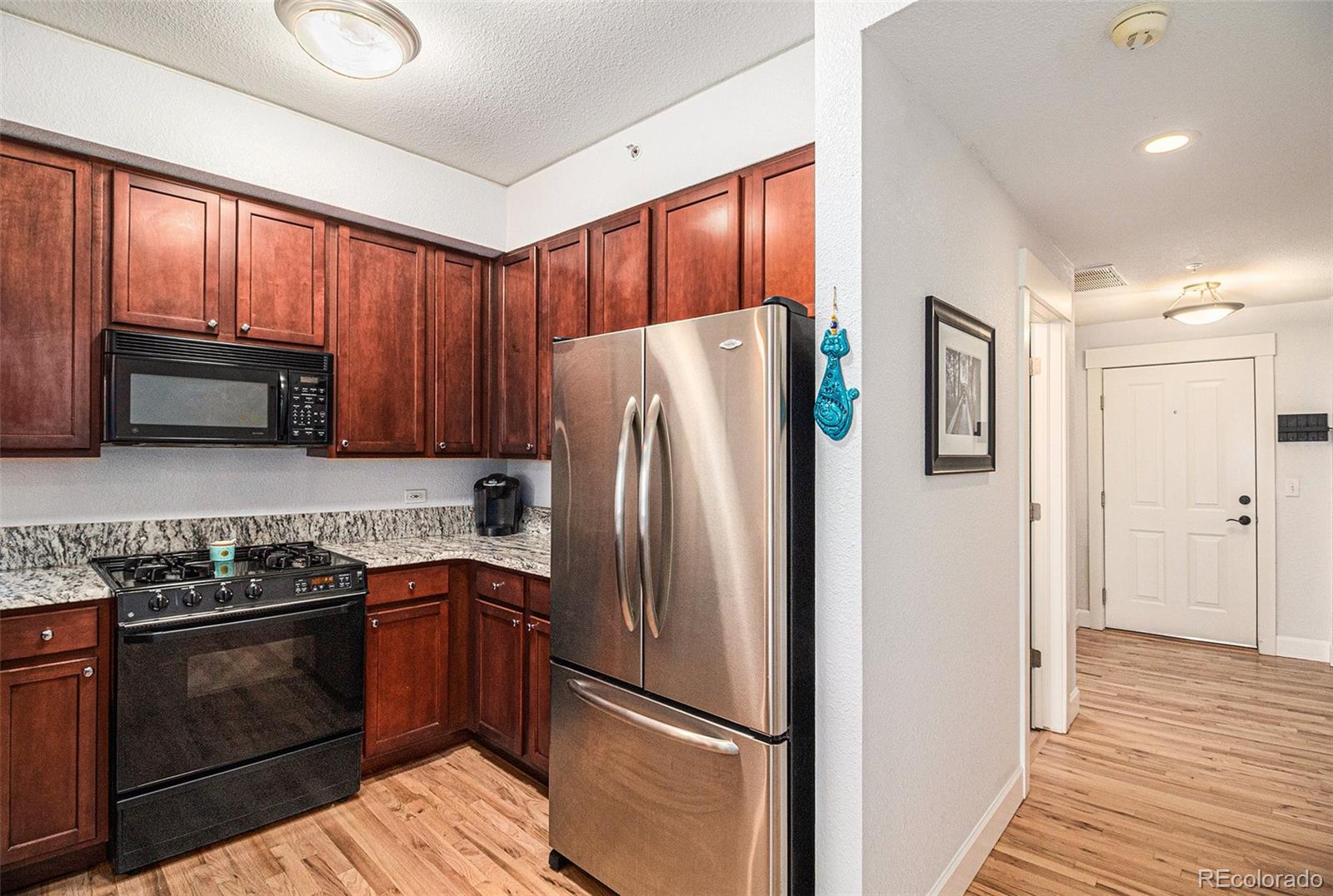 1699 North Downing Street, Unit 302 Denver, CO 80218 - Photo 9 of 23 a kitchen with stainless steel appliances granite countertop a refrigerator stove and sink
