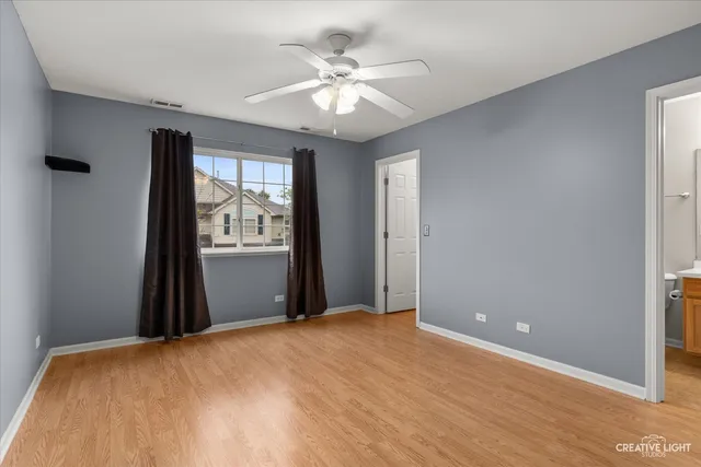 a view of a livingroom with a chandelier fan and wooden floor