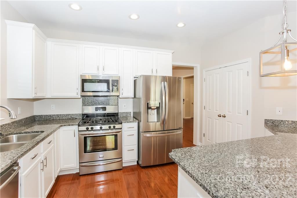 118 West Decatur Avenue Mooresville, NC 28117 - Photo 8 of 17 a kitchen with a refrigerator and a stove top oven