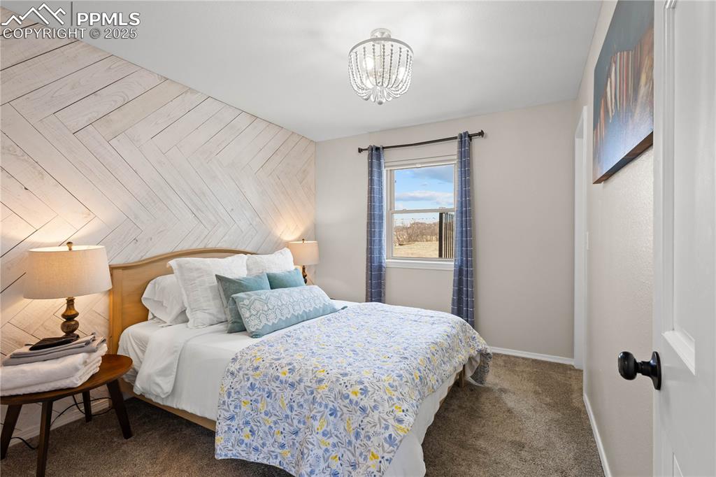 545 Struthers Loop Colorado Springs, CO 80921 - Photo 23 of 48 a bedroom with a bed and a chandelier