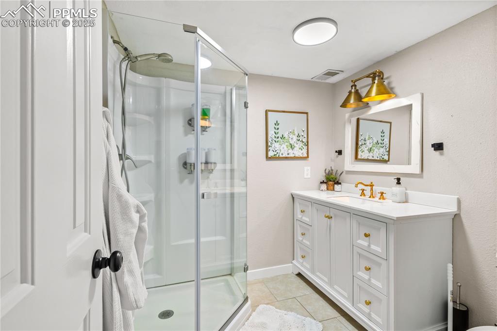 545 Struthers Loop Colorado Springs, CO 80921 - Photo 34 of 48 a bathroom with a shower sink and mirror