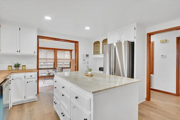 a kitchen with stainless steel appliances granite countertop a sink a stove and a wooden floors