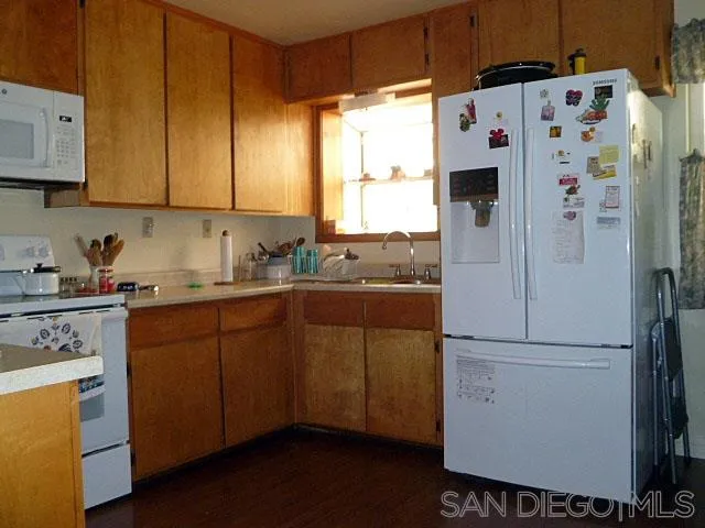 9236 Los Coches Road Lakeside, CA 92040 - Photo 8 of 27 a kitchen with a refrigerator and white cabinets