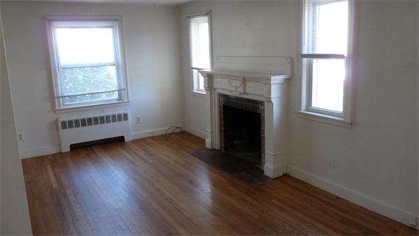 46-48 Hatfield Road Newton, MA 02465 - Photo 8 of 11 an empty room with wooden floor windows and fireplace