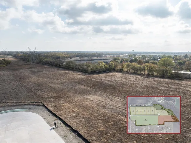 a view of a dry yard with wooden fence