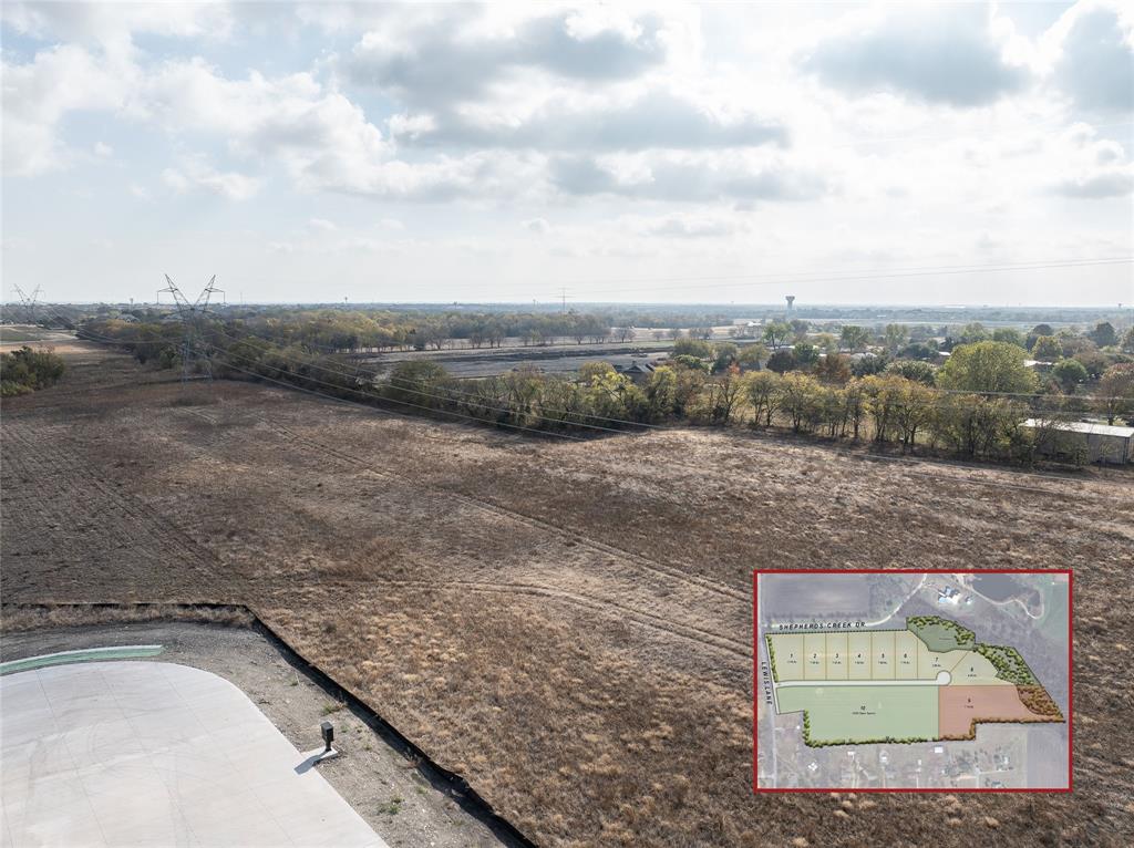 a view of a dry yard with wooden fence