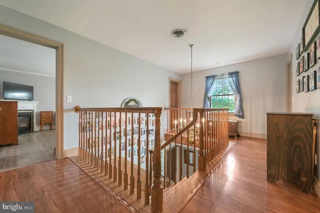 a view of a hallway with wooden floor and windows