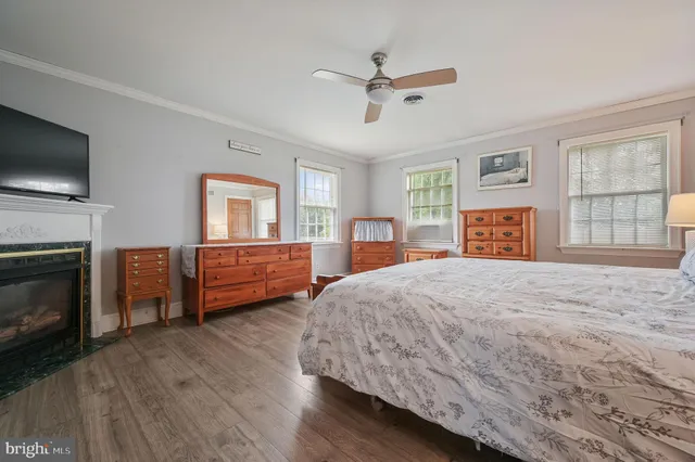 a spacious bedroom with a bed and wooden floor