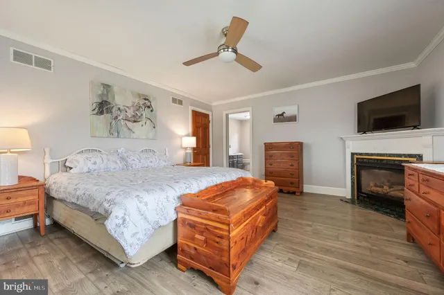 a spacious bedroom with a bed and a flat screen tv