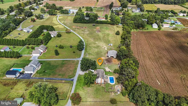 an aerial view of a residential houses with outdoor space and street view