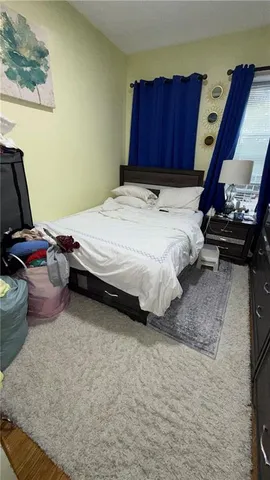 a bed sitting in a bedroom next to a window