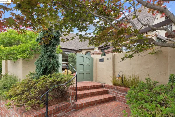 a front view of a house with a tree
