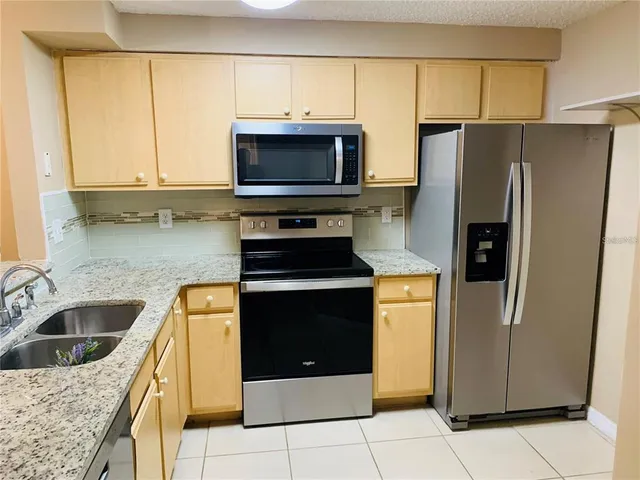 a kitchen with stainless steel appliances granite countertop a refrigerator stove and sink