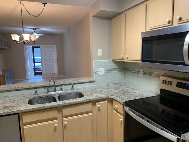 a kitchen with stainless steel appliances granite countertop a sink stove and microwave