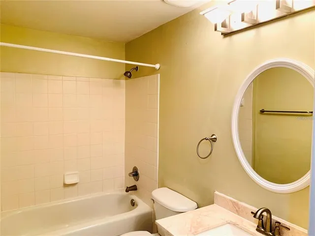 a bathroom with a sink mirror vanity and toilet