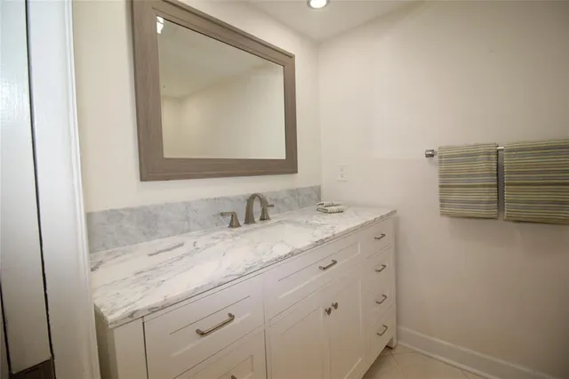 a bathroom with a granite countertop sink vanity mirror and