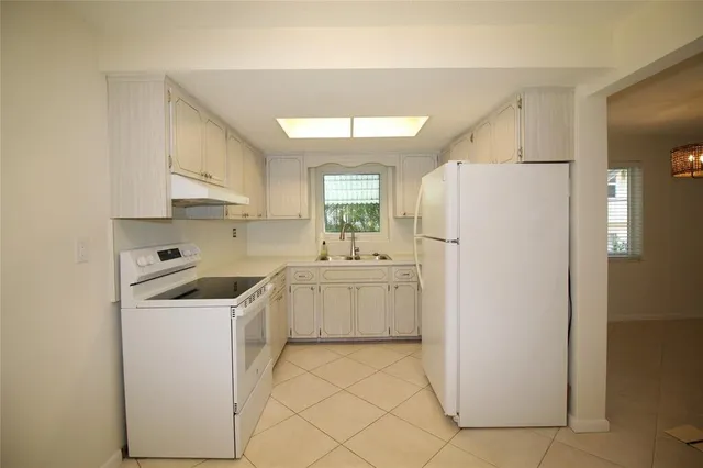 a kitchen with a refrigerator sink stove and cabinets
