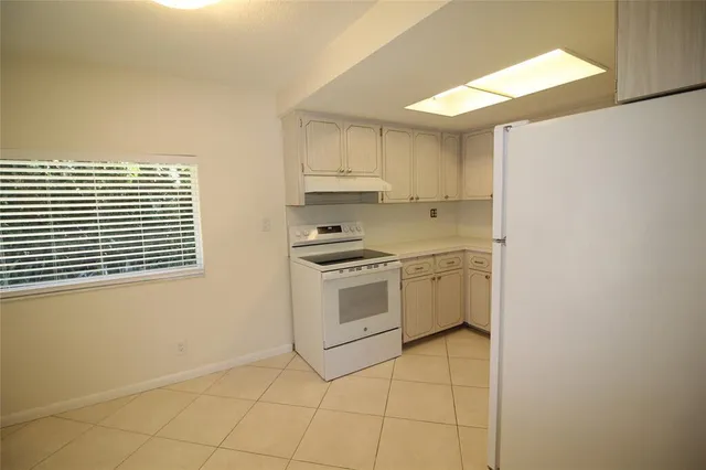 a kitchen with white cabinets and white appliances