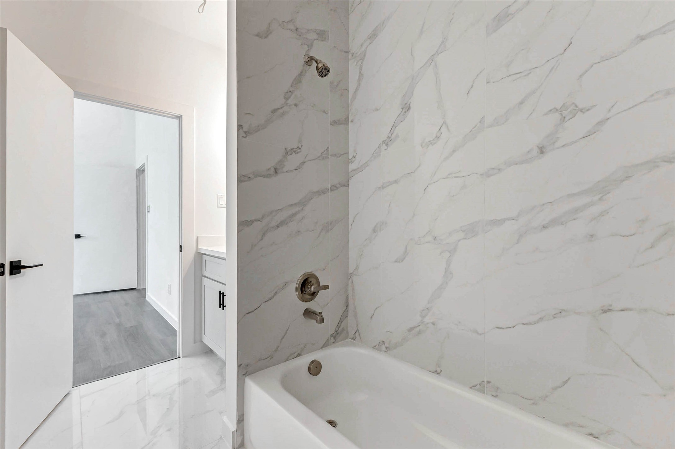 6017 Beall Street Houston, TX 77091 - Photo 28 of 33 Luxury and durability combine in this porcelain-tiled tub/shower combo. The marble-look walls and brushed nickel fixtures add a timeless elegance to your daily unwind.